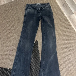 Svarta bootcut jeans - Säljer ett par svarta bootcut jeans i bra skick. De har en klassisk femficksdesign och är lågmidjade för en avslappnad look. Perfekta för både vardag och fest!