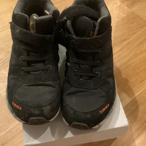 Svarta sneakers från Treksta - Säljer ett par svarta sneakers från Treksta i bra skick. De har snörning och är perfekta för höst och vår. Skorna är i storlek dam 38 och har en bekväm passform.