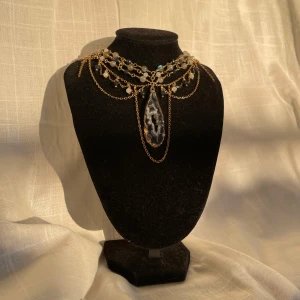 Handgjort halsband - Hänget på detta halsbandet är en vacker agat geode med en guldig ram. Jag har använt olika sorters pärlor i denna design, både vita och blåa små glaspärlor samt pärlor i labradorit som skiner fantastiskt i solen. För extra detaljer har jag använt mig av pyttesmå guldiga pärlor<3  Halsbandet har en förlängningskedja men går att förlänga eller förminska vid behov:)  Mått: 34cm-36cm  Pris: 959kr (spårbar frakt är inkluderat i priset) 