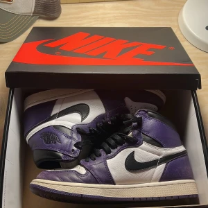 Jordan 1 High Court Puprle - Har använts försiktigt, lite sliten vid tårna och lite creases där fram men annars fina! Köptes av en vän därav inget kvitto. Storlek 41. Creaseskydd ingår! 