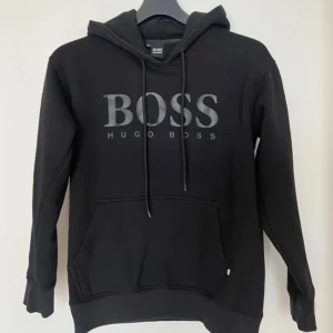 Svart hoodie från Hugo Boss - Snygg svart hoodie från Hugo Boss, jätte bekväm men är för liten för mig, jag är 180 62 kg. Skriv om ni har några frågor 💫💫💫