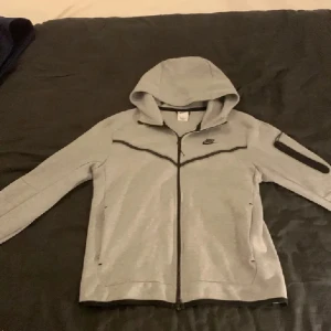 Grå Nike tech flecce - Tja, säljs pågrund av att jag inte använder den längre. Använd max 5 gånger så den är i väldigt bra skick. Köpt på Nikes hemsida för 1300. Kom med prisförslag om priset inte passar
