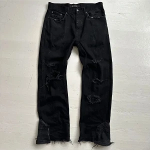Svarta custom flared jeans - Feta svarta flares, bilder tagna från förra ägare, har sytt in svarta/gråa patches under hålen. Mått skickas i dm, offer.