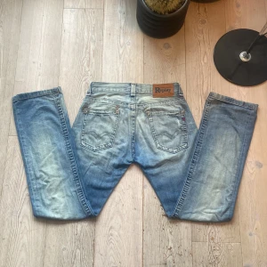 Blå jeans från Replay W30 L34 - Säljer ett par snygga blå jeans från Replay med en klassisk femficksdesign. De har en lätt tvättad look och en normal passform. Perfekta för en avslappnad stil. W30L34