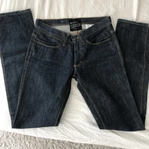 Mörkblå jeans från Acne - Säljer ett par mörkblå jeans från AcneDe har en klassisk femficksdesign och är tillverkade i slitstarkt denim. Low waist!