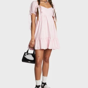 Rosa klänning från Dollskill - Sweet Gentle Disposition Babydoll Dress (märke: Mable), köpt på Dollskill för ca 843 kr och är slutsåld. En söt och romantisk klänning med puffärmar och rosetter. Klänningen har ett fint rutigt mönster och en söt volangdetalj i nederkanten. Sparsamt använd, fint skick. Storlek S.  Rökfritt hem men har katter.