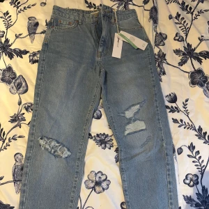 Blå jeans med slitningar - Snygga blå jeans från Gina tricot med slitningar på benen.