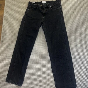 Straight fit Calvin Klein jeans - Snygga svartgråa jeans från Calvin Klein med straightlegged passform. Perfekt för en stilren look! Byxorna är i utmärkt skick och endast använts 2-3 gånger, därav är skicket 9/10. Storlek  är ”w30” och passar perfekt på mig som har 29-31 i midja samt 32-34 i längd. Midjan är 44 cm bred och byxan är 106 cm lång.