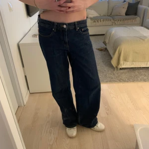 Mörkblå jeans med vid passform - Snygga mörkblå jeans med vid passform och låg midja. Perfekta för en avslappnad stil. Klassisk design med fem fickor och knappgylf.