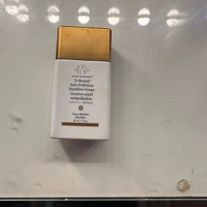 D-Bronzi Anti-Pollution Sunshine Drops - Säljer D-Bronzi Anti-Pollution Sunshine Drops från Drunk Elephant. Denna produkt ger en solkysst look och skyddar mot föroreningar. Kommer i en praktisk flaska med guldlock. Perfekt för att ge huden en naturlig bronston.