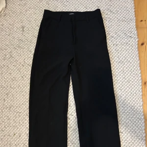 Svarta kostymbyxor från Lindex - Snygga svarta kostymbyxor från Lindex i modellen Noor. De har en klassisk design med raka ben och hög midja. 