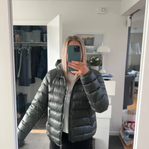 Grön dunjacka från Colmar - Säljer en snygg grön dunjacka från Colmar köpt för ca 5000. Jackan är sparsamt använd och har ngr fläckar på ena armen som man inte ser jättetydligt när man väl använder den. Har inte testat att tvätta den, men det går säkert att göra för att få bort det. Jackan är i storlek 50 (inte svensk storlek skulle gissa att det är M/L) men passar mig som är s/m. 