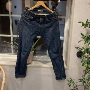 Jack and Jones jeans - Ett par mörkblåa Jack and Jones jeans som är storlek 28/30 Och dem har ett litet håll i höger ficka 