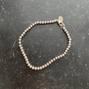 Silverfärgat pärlarmband - Elegant armband med små silverfärgade pärlor. 18 cm långt.