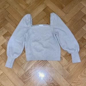 Beige stickad tröja med puffärmar - Säljer en superfin beige stickad tröja med puffiga långa ärmar. Perfekt för höst och vår, den är både stilren och mysig. Tröjan har en fyrkantig halsringning och ribbade muddar vid ärmslut och nederkant. Passar perfekt till både jeans och kjol!