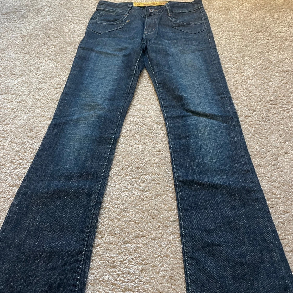 Mörkblå jeans med broderade bakfickor