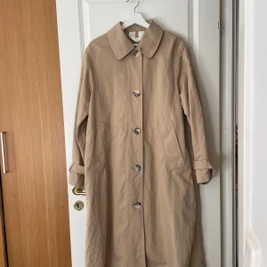 Beige trenchcoat - Klassisk beige trenchcoat från Arket i strl. 34. Bra skick med lite skavanker (se bilder) kan skicka fler bilder.