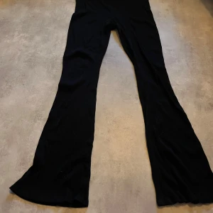 Svarta ribbade byxor - Säljer ett par svarta ribbade byxor i storlek L. Bootcut-stil som ger en snygg siluett.