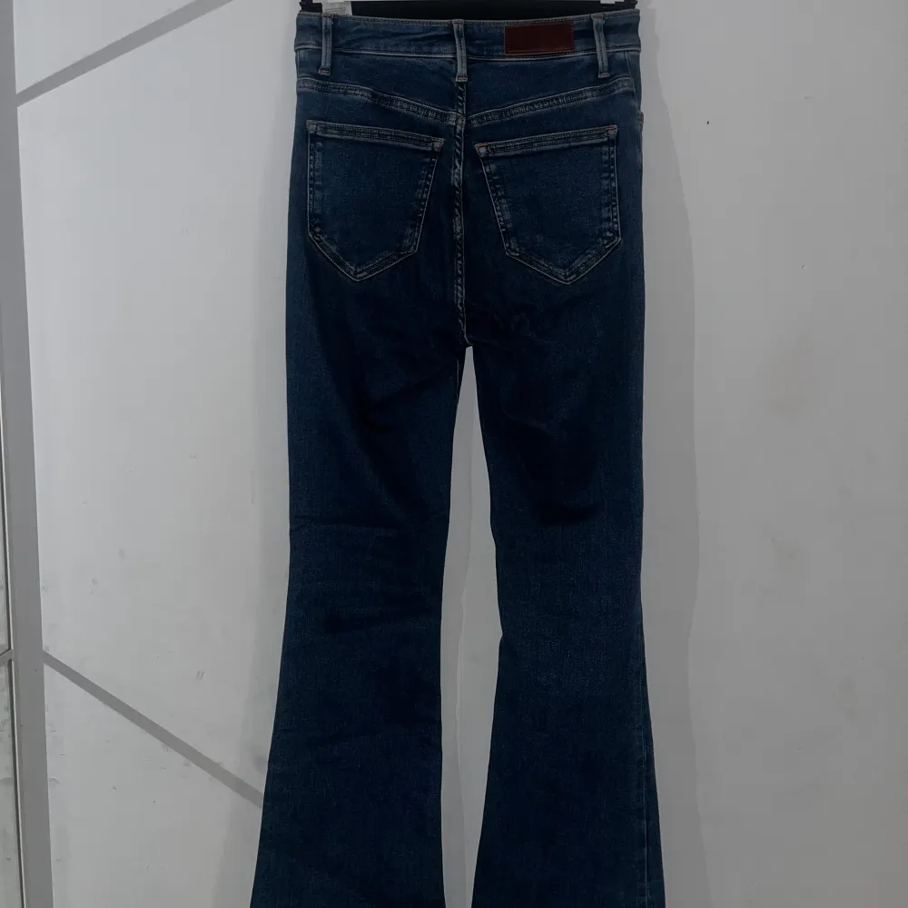 Säljer ett par snygga blå Peachy Flare jeans i storlek S. De har en hög midja och en cool bootcut-stil som ger en retro vibe. Perfekta för både vardag och fest! De är i mycket bra skick och har en klassisk femficksdesign.. Jeans & Byxor.