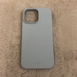 Ljusblått mobilskal - Säljer ett stilrent ljusblått mobilskal i syntetmaterial. Skalet har en slät yta och är designat för att skydda din telefon samtidigt som det ger ett snyggt utseende. Perfekt för dig som vill ha ett enkelt men elegant skydd för mobilen. Mobil skalet är iphone 14 pro max och är helt nytt, säljer pga felköp!