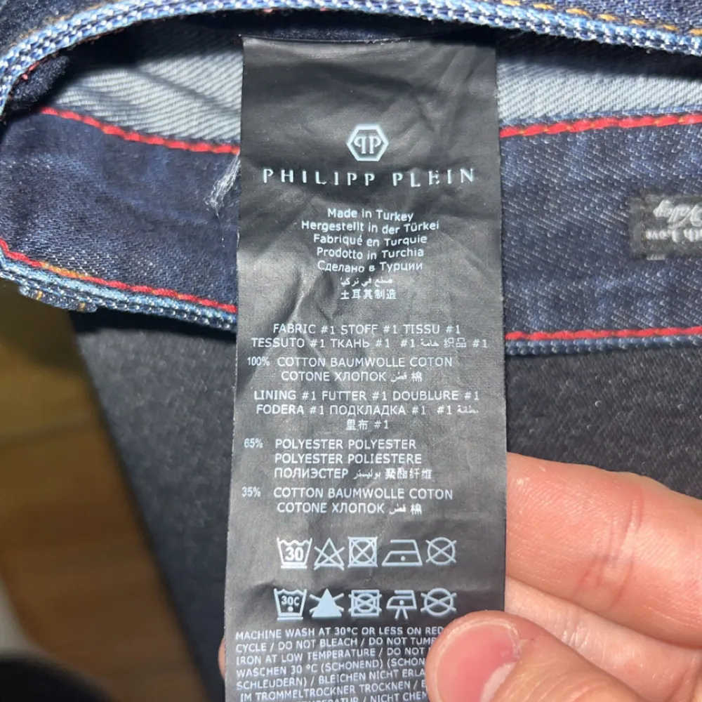 Snygga Philipp Plein jeans i mörkblå denim med coola detaljer som en unik knappdesign och logotyp på bakfickan. Tillverkade i Turkiet med en blandning av bomull och polyester för en bekväm passform. Perfekta för både vardag och fest!. Jeans & Byxor.