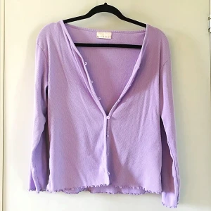 Ljuslila ribbad kofta från Best Basics - Säljer en superfin ljuslila kofta från Best Basics. Den är ribbad med långa ärmar och har söta små knappar framtill. Perfekt för både vår och sommar! Den har en lite vågig kant nertill som ger en extra touch. Passar perfekt till jeans eller en kjol. 💜