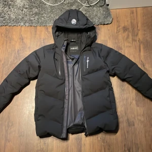 Svart dunjacka från Sailracing Pris kan diskuteras - Säljer en varm och snygg Sail racing jacka med mycket bra skick bara använd ett fåtal gånger. Nypris är 4500. storlek 170, Pris kan diskuteras.