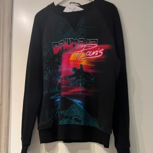 Svart tröja med tryck från Balmain - Oanvänd Balmain tröja i stolek M. Ligger i original plastpåse, lappar och orderbekräftelse finns.