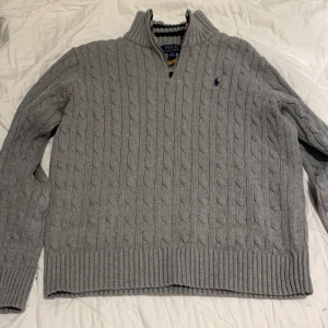 Grå stickad tröja från Polo Ralph Lauren - Säljer en snygg grå stickad tröja från Polo Ralph Lauren. Den har en klassisk kabelstickad design med en liten broderad logga på bröstet. Tröjan har långa ärmar med ribbade muddar. Perfekt för kyliga dagar! Nypris ≈ 2000 tveka inte om att höra av dig! Storlek: 14-16 år barnstorlek: XL Vuxenstorlek: S