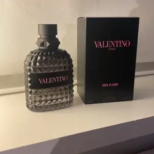 Säljer en lyxig parfym från Valentino, Uomo Born in Roma. Flaskan är stiligt designad med ett mönster av små pyramider och har en elegant svart färg. Den rymmer 100 ml och kommer i en snygg svart kartong. Perfekt för den som vill ha en sofistikerad doft med en touch av italiensk elegans. Cirka 99ml kvar då jag endast testat den.