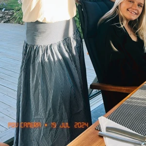 Randig långkjol i blått och vitt - Säljer en superfin långkjol med blå och vita ränder. Kjolen har en bekväm passform och är perfekt för sommardagar. Den är gjord i ett lätt och luftigt material, vilket gör den idealisk för varma väder. Passar både till vardags och festligare tillfällen!