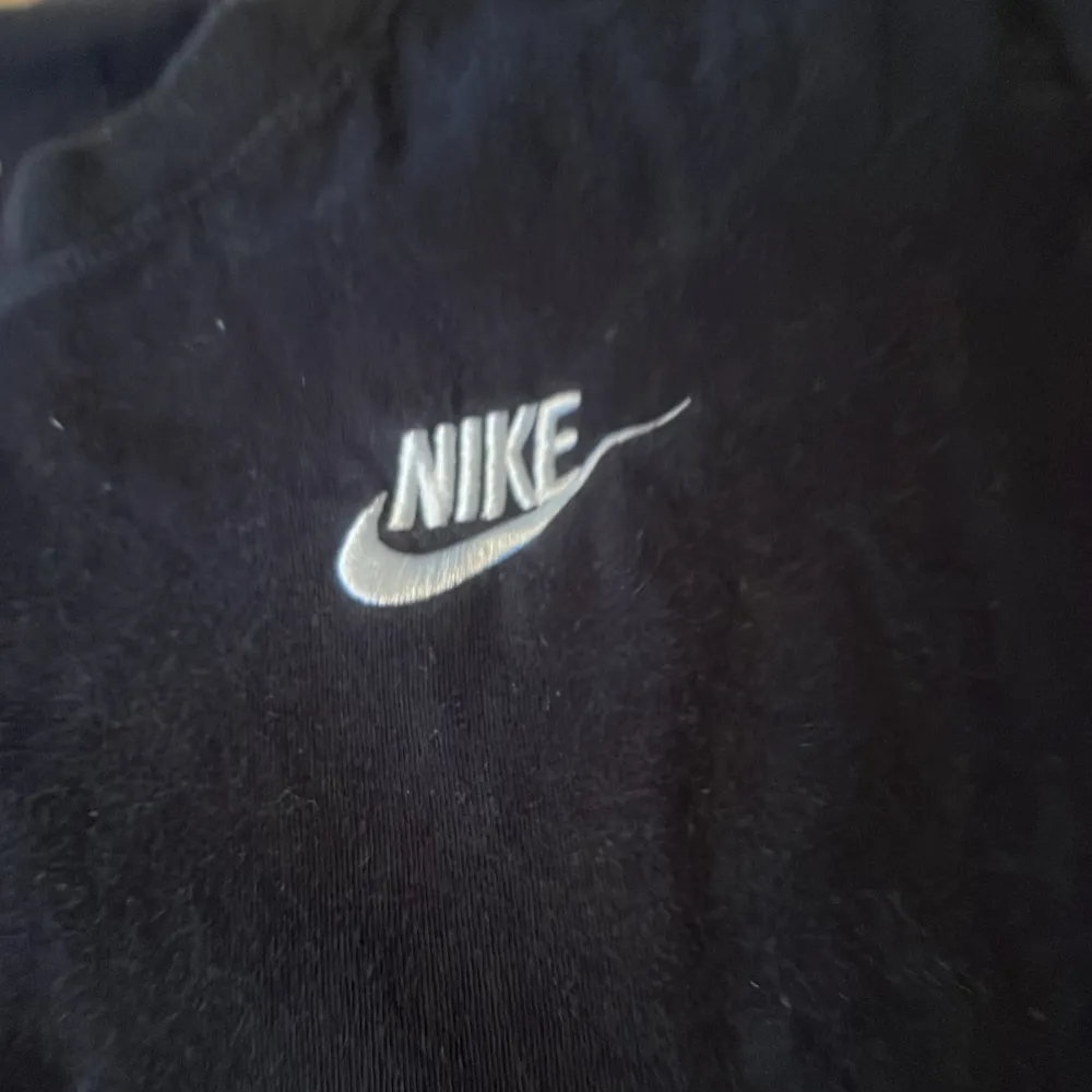 Två snygga t-shirts från Nike i svart och beige. Båda har korta ärmar och det klassiska Nike-loggan broderad på bröstet. Perfekta för en avslappnad stil eller träning. De är i bra skick och gjorda av mjuk bomull för extra komfort.. T-shirts.