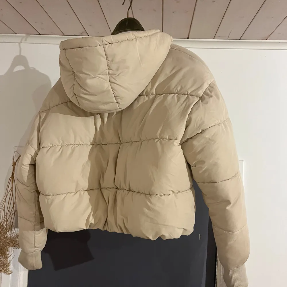 Säljer en supermysig beige pufferjacka från Monki i storlek M som är croppad. Jackan har en dragkedja framtill och en skön huva. Perfekt för kyliga höst- och vinterdagar. Den är i mycket bra skick.. Jackor.