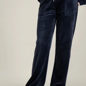 Mörkblå Juicy byxor - Säljer ett par snygga mörkblå juicy byxor i storlek 140-146 från kidsbrandstore men passar mig och jag är 160cm. De har en loose passform och är perfekta för en avslappnad stil. Byxorna har fickor och en bekväm midja med snörning. Perfekta för höst och vinter! Säljer för 250 då köpte för 900!