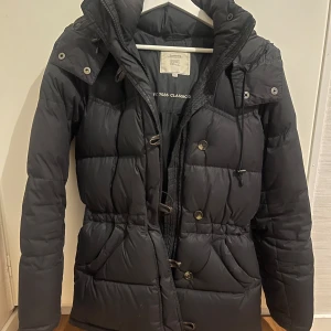 Svart dunjacka från Boomerang - Superfin svart boomerangjacka, perfekt till vintern då den värmer  superbra! Den är använd, men fortfarande i väldigt bra skick, inga defekter eller liknande. Den kemtvättades senast i början av året, skulle inte påstå att det behövs igen, om det inte önskas såklart. Allt sitter som det ska, går att reglera i midjan. Inget slitage alls på muddarna. Priset går att diskuteras vid snabb affär!🩷