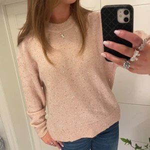 Ljusrosa glittrig tröja - Säljer en superfin ljusrosa tröja med glittriga detaljer. Den är perfekt för både vardag och fest! Tröjan har en normal passform och långa ärmar, vilket gör den mysig och stilren. Passar perfekt till jeans eller kjol för en chic look. ✨