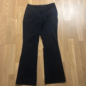 Mörkblåa lågmidjade kostymbyxor  - Mörkblåa kostymbyxor från H&M i storlek 36. Byxorna är lågmidjade och bootcut samt i väldigt bra skick!