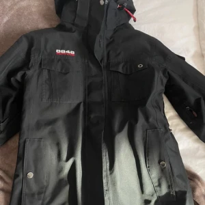 Svart jacka från 8848 Altitude - Säljer en svart jacka från 8848 Altitude i mycket bra skick. Den är perfekt för utomhusaktiviteter med sitt slitstarka material och funktionella design. Jackan har en dragkedja, flera fickor och en justerbar huva. Insidan är quiltad för extra värme och komfort. Perfekt för höst- och vinteräventyr! 🏔️