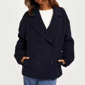 Marinblå kappa - Säljer en marinblå kappa i mycket bra skick. Den har en oversized passform med dubbelknäppning och långa ärmar. Perfekt för höst och vår. Jag köpte den förra åter och har använt den några gånger. Det är storlek S men funkar bra på någon med storlek M för den är oversized