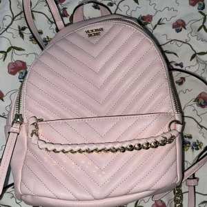 Rosa quiltad ryggsäck från Victorias Secret - Superfin rosa ryggsäck från Victorias Secret i quiltat mönster. Den har en snygg kedjedetalj på framsidan och dragkedja upptill. Perfekt för både vardag och fest! 👜✨aldrig använd och suuuperfin men aldrig haft användning för den där utav försäljningen och priset kan diskuteras vid snabb affär!💋