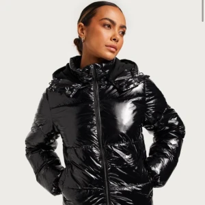 Glansig svart jacka  - Säljer min jacka från Nelly då jag inte kommer använda den, köptes för 800 säljer för 500!  Den är i fint skick och är inte så använd. Skriv om ni skulle vilja ha fler bilder med den på osv. 