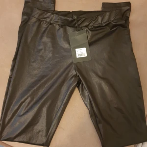 Svarta byxor från Sisters Point - Snygga svarta byxor från Sisters Point i storlek S. De har en glansig finish som ger en cool look. Tunna och supermjuka som leggings. Perfekta för en utekväll eller fest! Helt nya med lapp kvar. 