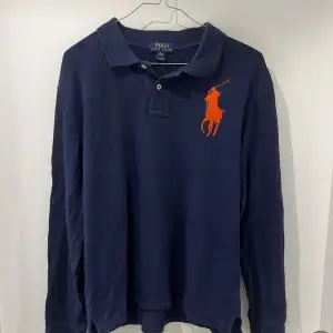 Säljer en snygg mörkblå pikétröja från Ralph Lauren i storlek M/L beroende på längd. Tröjan har en stor logga på bröstet och en siffra '3' på ärmen. Passar perfekt med en vit t-shirt under. Skicket är bra 8/10. Hör gärna av dig vid funderingar! 