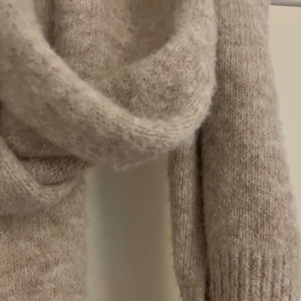 Säljer en supermysig beige stickad halsduk som är perfekt för kyliga dagar. Den är riktigt mjuk och varm, vilket gör den idealisk för höst och vinter. Halsduken har en enkel och stilren design som passar till det mesta i garderoben. Perfekt för att hålla stilen och värmen samtidigt!. Övrigt.