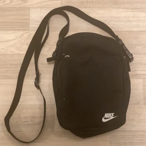 Säljer Nike axelremsväska  - Smidig väska för att bära med sig det man behöver och fortfarande ha platts för sina händer i byxfickorna  Bra skick 