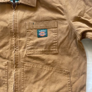 Jameson X Dickies Workwear Jacket - En workwear jacka från Dickies med Jamesondetaljer, sitter lite lägre än midjan på mig som är 179, den är i M men känns större än så! Pris går att diskuteras!