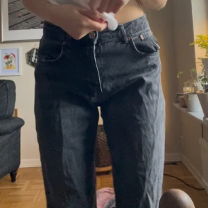 Svarta jeans - Säljer ett par svarta jeans i straight fit. De är midwaist och har en klassisk design med dragkedja och knappar. Perfekta för både vardag och fest!