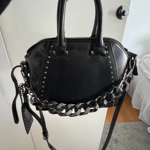 Aldo väska - Jag säljer min Aldo väskan som inte kommer till användning, kedjor kan man ta av på väskan och banden är justerbara. Orginal pris cirka 800kr❤️