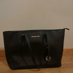 Michael kors väska - Säljer min svarta michael kors väska då den är lite större än vad jag vill ha den. Den är svart och silvrig. Rymlig och i fint skick!  Skriv för fler bilder eller om du har frågor. Pris går att diskuteras:)❤️ banden är lite slitna(skriv för fler bilder) 