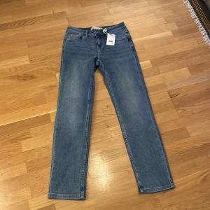 Blå jeansbyxor - Säljer ett par klassiska blå jeansbyxor i nyskick. De har en straight passform och är perfekta för vardagsbruk. Byxorna har en normal midja och är tillverkade i ett slitstarkt denim-material. Perfekta för både höst och vår!
